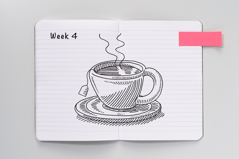 An open notebook with a sketch of a cup of tea